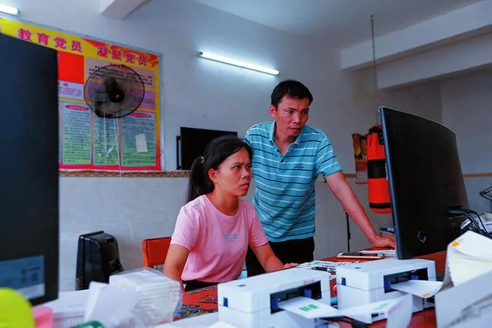 ▲在自家小楼的“运营中心”里，江文毅夫妇正在查看店铺后台的订单 （颜篁/摄）