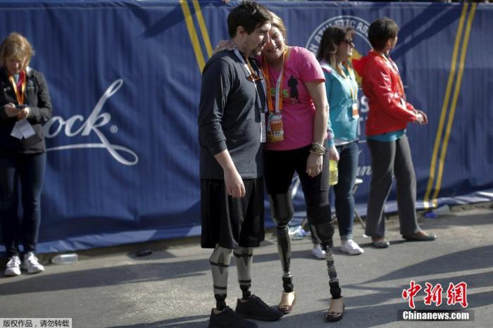 资料图：当地时间2016年4月18日，美国波士顿马拉松比赛开跑。两位爆炸案受害者相拥，他们都在此前的爆炸案中失去双腿。