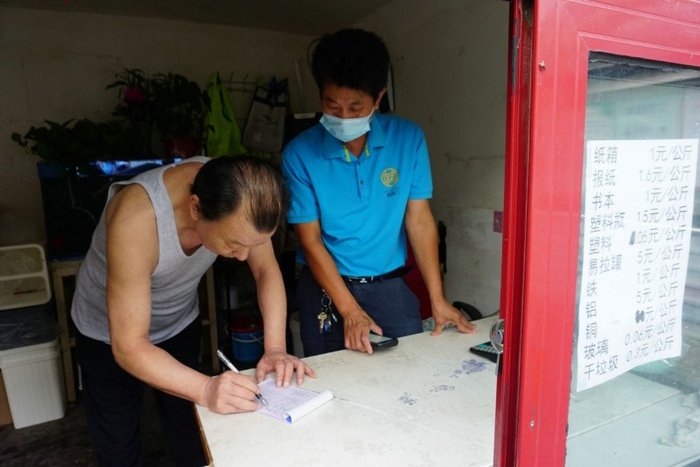 宝盖胡同绿色生活驿站，居民在处理可回收垃圾