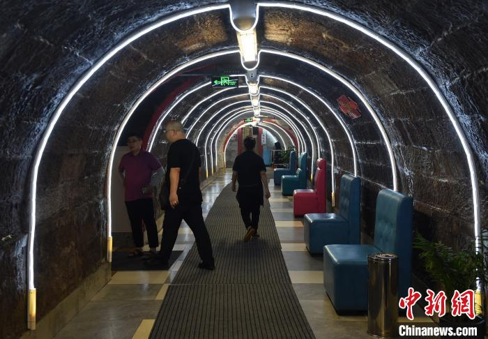 图为市民行走在防空洞火锅馆时光隧道。　周毅 摄