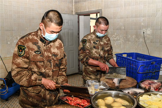 　　代兴超（右一）给战友们准备午餐。