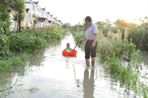 图说：河水倒灌给附近居民带来出行不便。杨嘉乐 摄