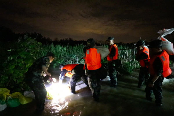 图说：筑起堤坝阻断倒灌河水。朱存栋 摄