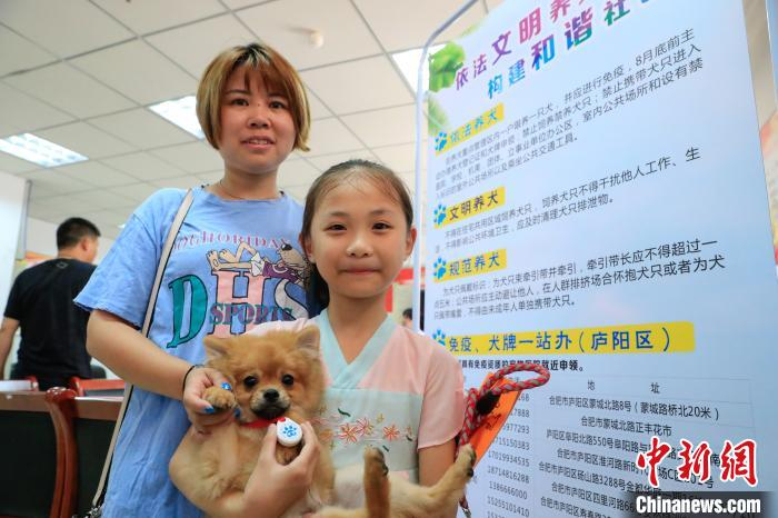 社区居民带着犬只前来登记办理养犬证。　赵明 摄
