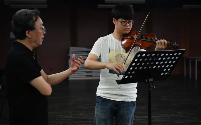 ▲中央音乐学院管弦系主任童卫东教授指导正在求职的学生刘镇源。目前，刘镇源已经被中国交响乐团录用。新京报记者 吴江 摄