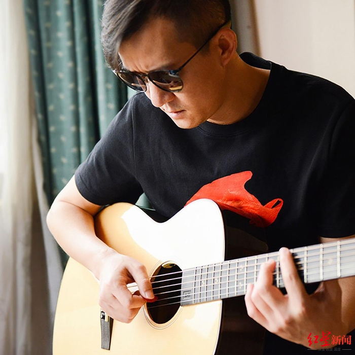 阿茂身着乐队LOGO红色塑料袋黑T恤