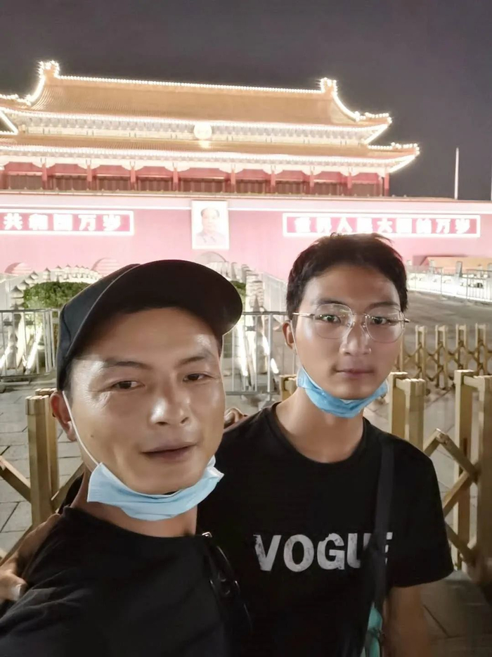 开学报到前，何润琪（右）与送他到北京的爸爸在天安门前合影留念。受访者供图