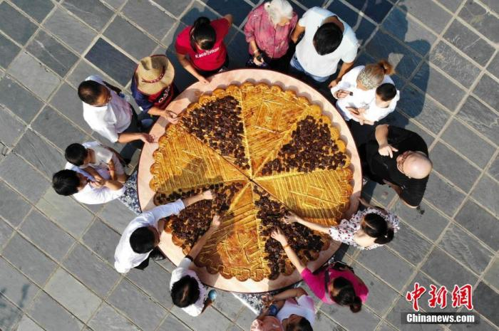 资料图：一块直径2米的巨型辣条月饼亮相湖南省平江县石牛寨，吸引众多游客与当地村民。中新社记者 杨华峰 摄