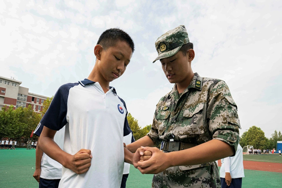     山东水利技师学院军训中，教官为一位同学纠正动作。山东水利技师学院供图