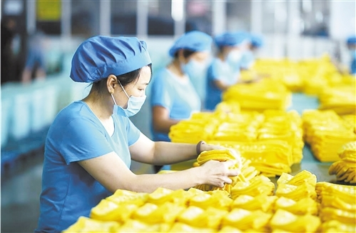 怡青舒袜业有限公司的员工正在生产线上工作。&nbsp; 陈发明摄