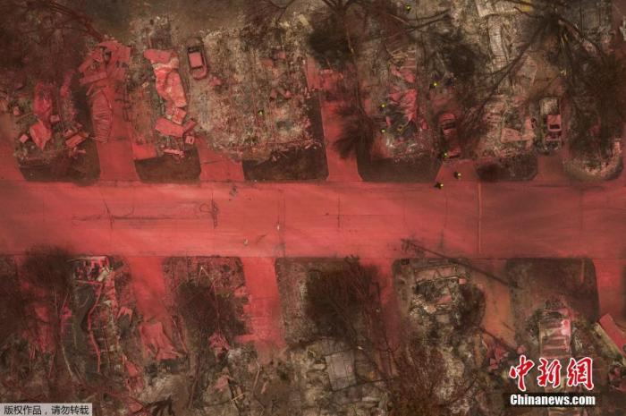 当地时间9月13日，美国俄勒冈州，当地消防喷洒红色阻燃剂扑灭阿尔梅达山火，大片的地面、多辆汽车、房屋、植被都被染红，搜救人员在废墟中寻找遇难者。