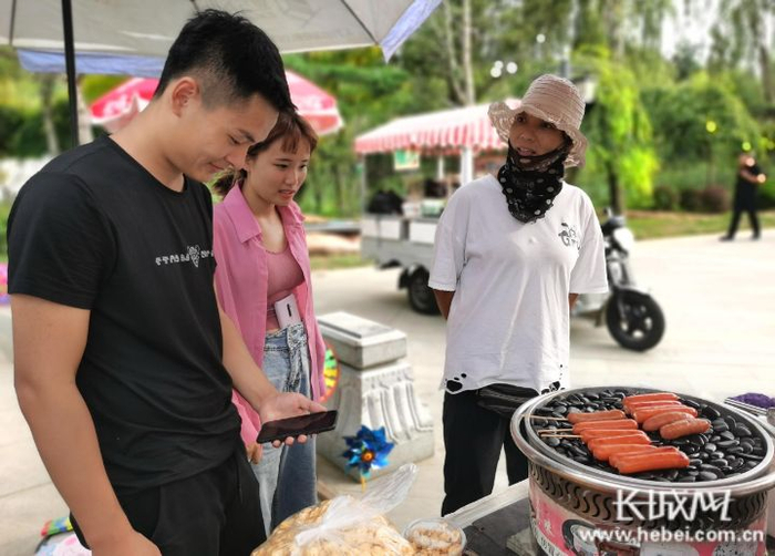 高玉芹（右一）在向游客介绍商品。长城网记者 郭庆敏 摄
