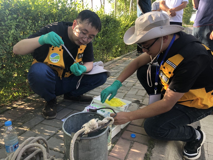 8月25日，胡立才（左一）和同事在湟水河边取水快速检测。摄影/新京报记者 邓琦