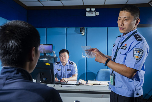 图说：吴俊与刑科所民警分析案发现场提取到的物证。普陀公安分局供图