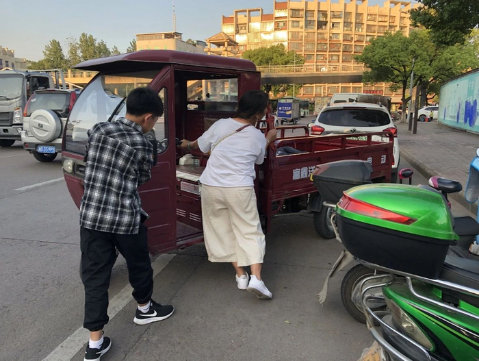  妈妈骑着电瓶车带奥华去永康西站唱歌，车里是重重的设备。新京报记者解蕾&nbsp;摄