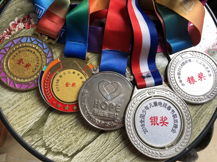  奥华参加歌唱比赛获得的奖牌。新京报记者解蕾&nbsp;摄