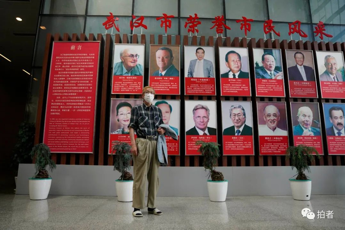 8月4日，武汉市民之家大厅，岛爷爷看到宣传栏上展出的武汉荣誉市民风采里有个两个日本人，要求与他们留影。岛爷爷说，回去要收集他们的素材，写文章介绍给日本人看。