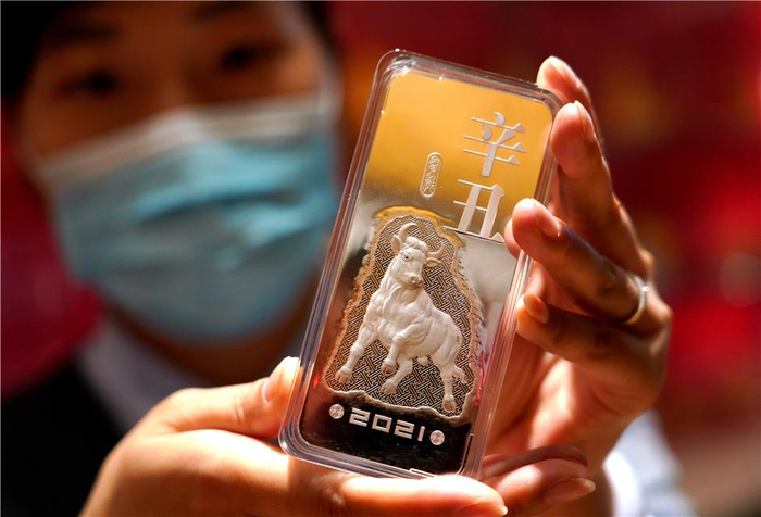 图为北京菜百公司工作人员展示辛丑牛年贺岁银条。