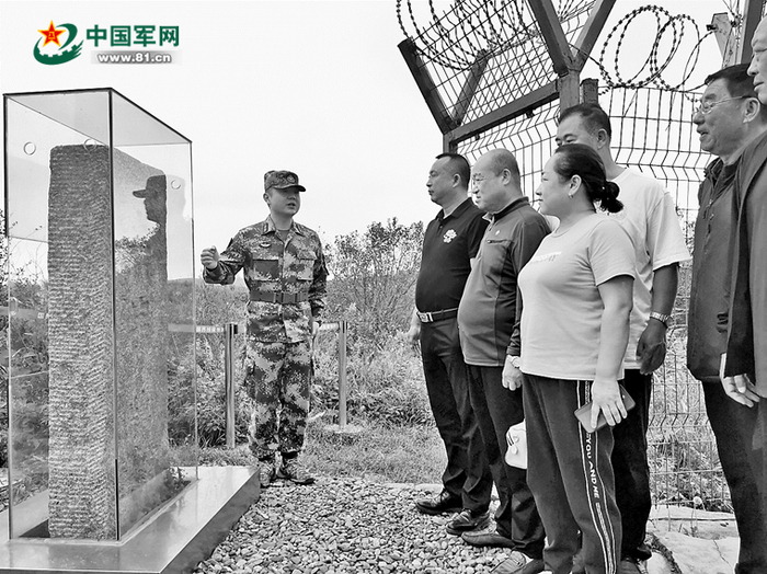 在“土字牌”界碑前，肖寒为游客讲解防川的历史。刘思琪摄