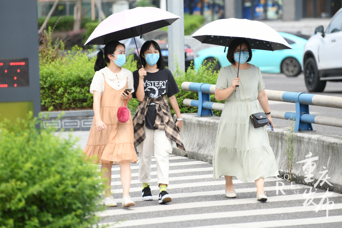 市民打着遮阳伞出门  邹乐 摄（资料图）