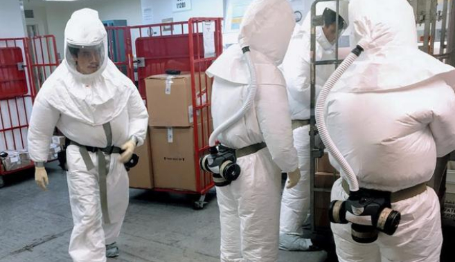 ↑美国工作人员穿防护服，检查寄给五角大楼的邮件。图据法新社