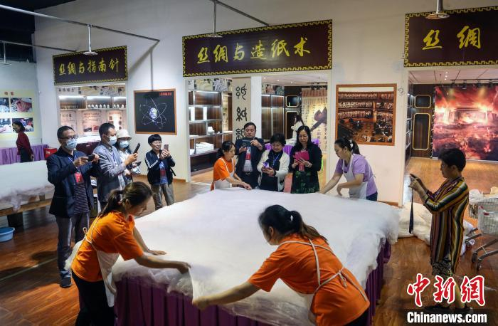 海外华文媒体代表纷纷拍下工人们拉蚕丝被的一幕。　王磊 摄