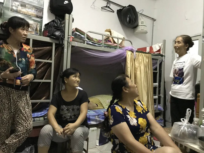 ▲8月22日晚，刘凤清（右二）在宿舍里与姐妹们聊天。新京报记者 张惠兰 摄