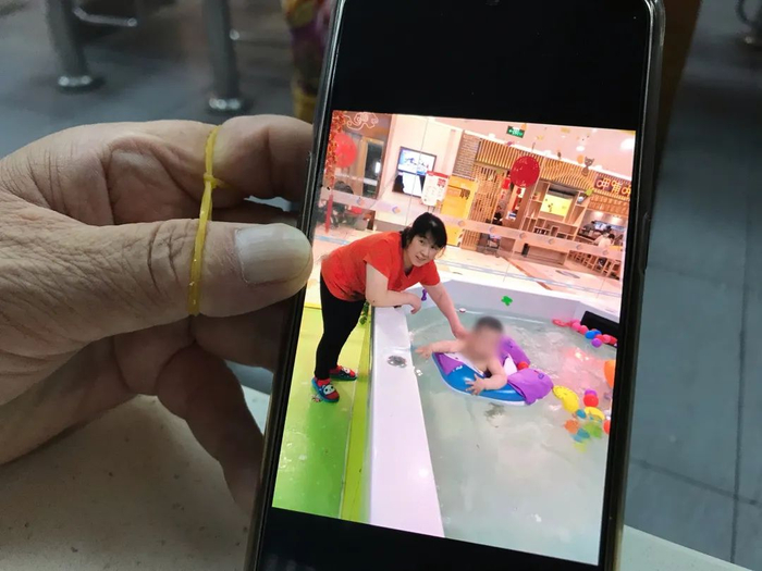 ▲刘凤清展示她与雇主家孩子的合照。新京报记者 张惠兰 摄