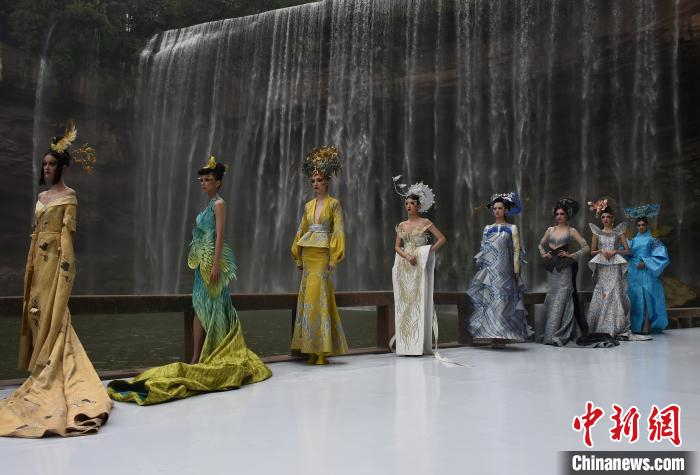 图为模特在以万州大瀑布为背景的秀场走秀。　周毅 摄
