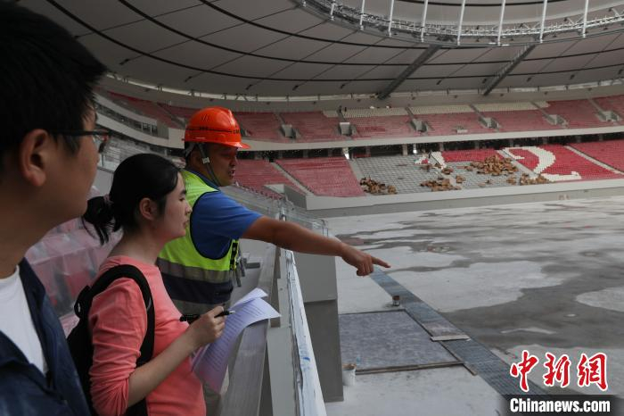 上海建工二建集团浦东足球场项目经理朱伟敏向记者介绍项目情况。　张亨伟 摄