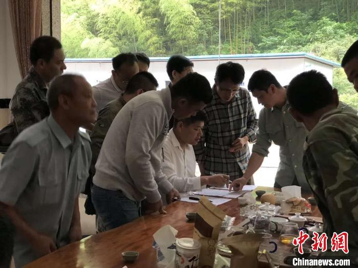 胡永飞和村民一起交流游客服务工作。(资料图) 吴隆重 摄