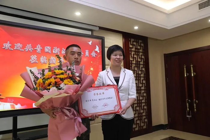  共青团浙江省委副书记王慧琳向王亮送上鲜花和“浙江青年五四奖章”的荣誉证书