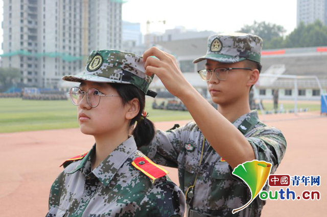 图为学生教官指导05后新生张同学训练。