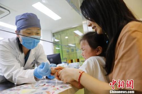 医护人员正在为孩子抽血化验 图源：中新网