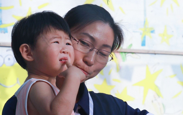 刘月抱着女儿田野。新京报记者 景如月 摄