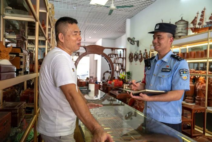 图为廖鹏在走访辖区商铺。黎运照 摄