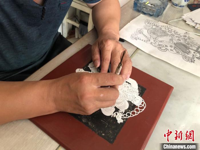 李宝峰在刻制剪纸作品。　郝烨 摄