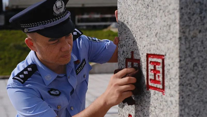 图为廖鹏在擦拭界碑。黎运照 摄