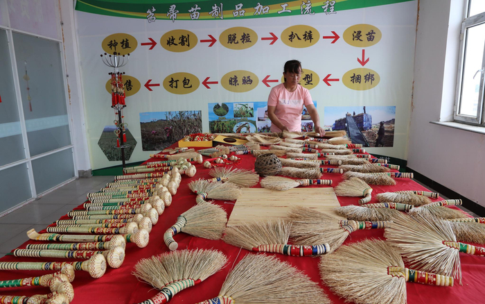 扶贫车间里贴着笤帚苗制品加工流程，便于工人们随时学习。受访者供图