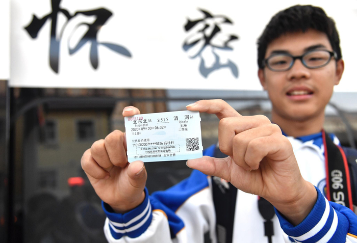 一名乘坐“怀密号”列车的学生手持第一班车票。摄影/新京报记者&nbsp;吴宁