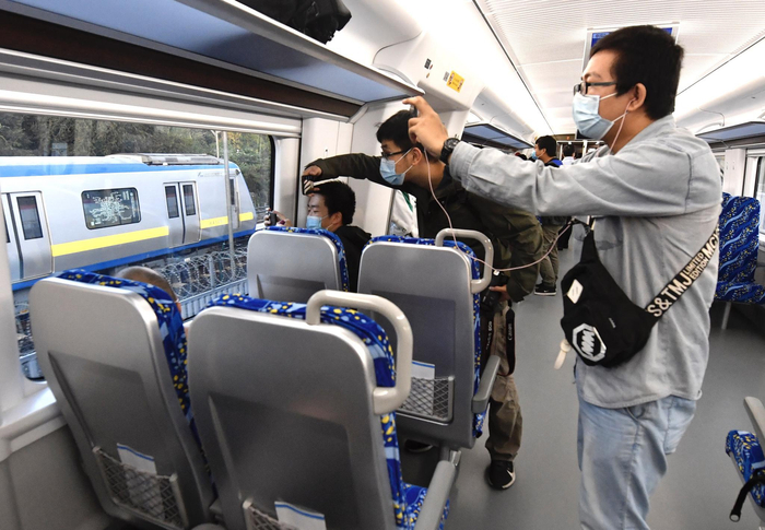 列车在去往清河站途中与13号城铁平行，旅客在拍照。摄影/新京报记者&nbsp;吴宁&nbsp;