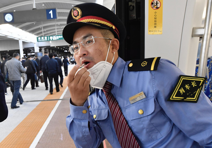 开车前列车长吹哨示意准备开车。摄影/新京报记者&nbsp;吴宁&nbsp;