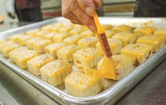 师傅为即将进炉烘焙的月饼刷蛋液。 深圳晚报记者 方舟 摄