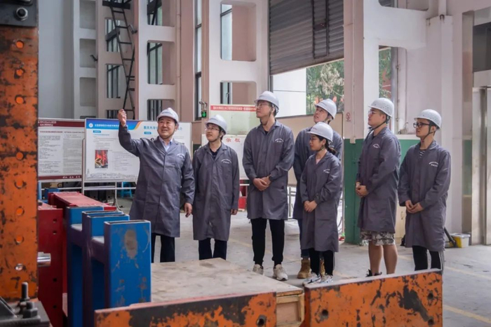 周绪红院士（左一）在土木工程学院结构实验室和团队成员讨论实验情况。重庆大学供图