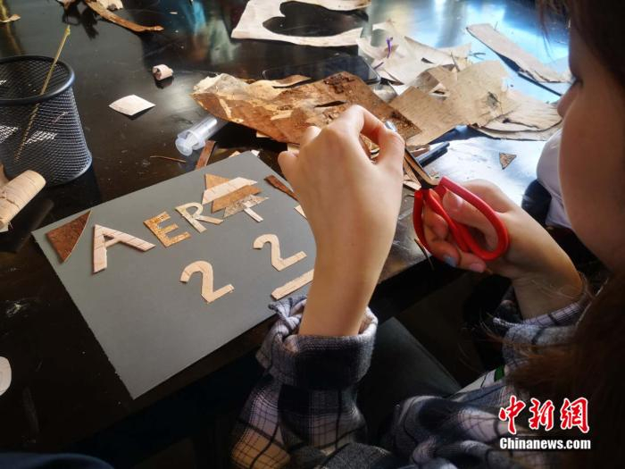  游客正在体验树皮画的制作。 郎朗 摄 