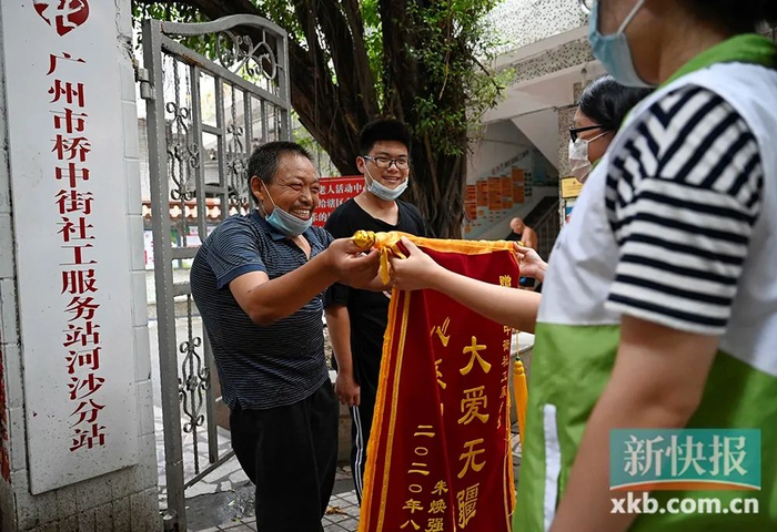 ▲2020年9月初，老朱带着阅阳到广州河沙村社工站送上锦旗，老朱说，阅阳能有今天要感谢很多人的帮助，他希望以后阅阳也能通过努力回报社会。