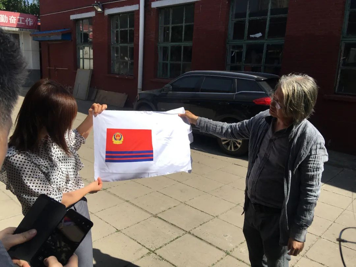 ▲刘波及其团队在室外比对警旗颜色视觉效果