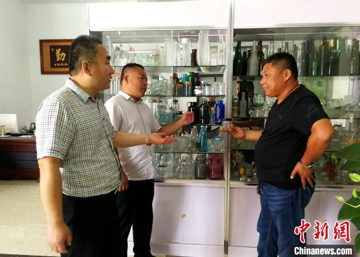 在五段镇电子商务玻璃制品展示中心，镇村两级负责人共同探讨富民“密码”。　朱志庚 摄