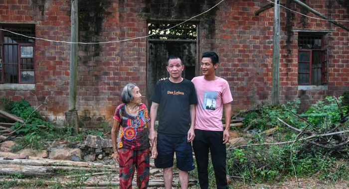  张玉环（中）和儿子与母亲在自己入狱前的住处前留影 图：新华社