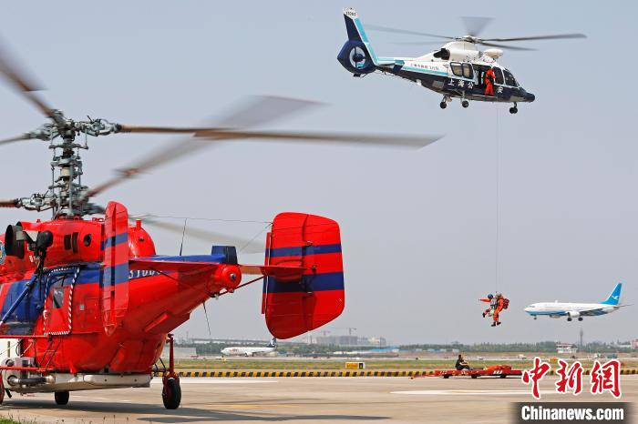 直升机悬停空中，救援队员索降营救伤员。　殷立勤 摄